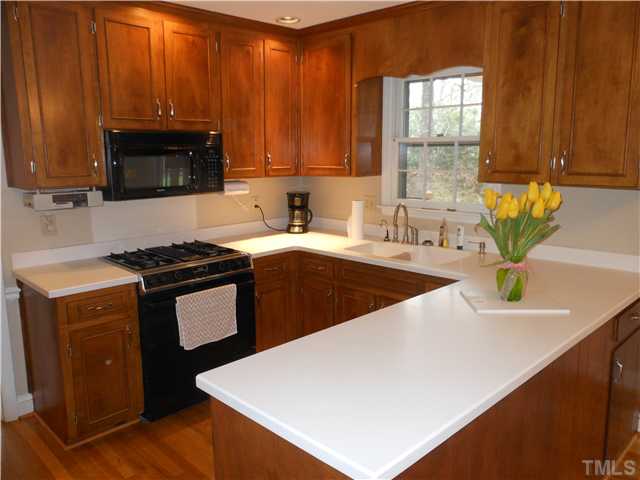 3504 Ranlo Drive Raleigh, NC 27612 - Photo 4 of 10 a kitchen with stainless steel appliances a sink a stove a microwave a sink a refrigerator and cabinets