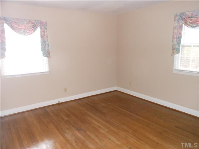 3504 Ranlo Drive Raleigh, NC 27612 - Photo 7 of 10 an empty room with wooden floor and windows