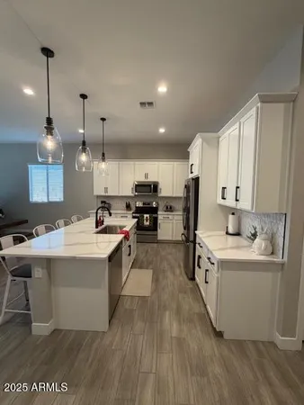 a large kitchen with kitchen island a sink a stove and a center island
