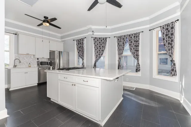 a kitchen with white cabinets and white appliances