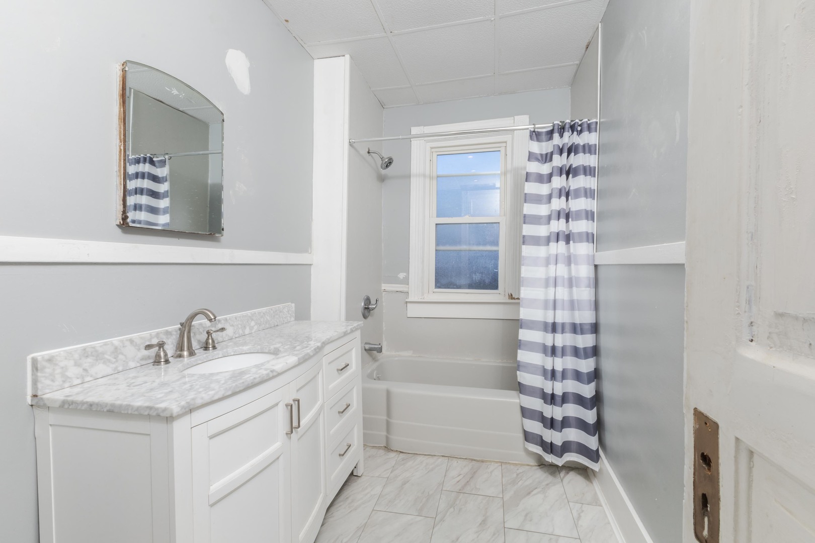 904 South Madison Street Bloomington, IL 61701 - Photo 19 of 46 a bathroom with a granite countertop sink a mirror and a bathtub