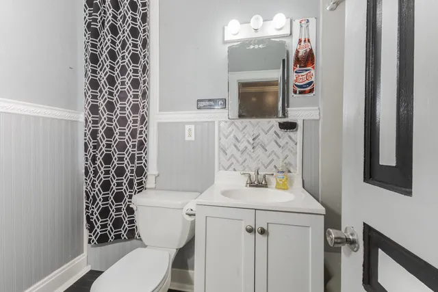 a bathroom with a toilet sink and mirror