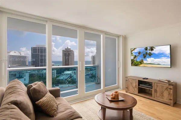 a living room with furniture and a floor to ceiling window