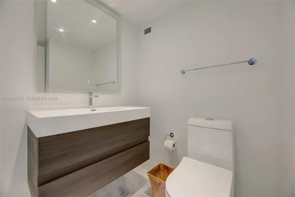 a bathroom with a toilet a sink and mirror