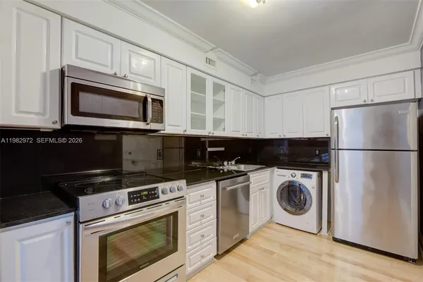 a kitchen with cabinets a stainless steel appliances and wooden floor