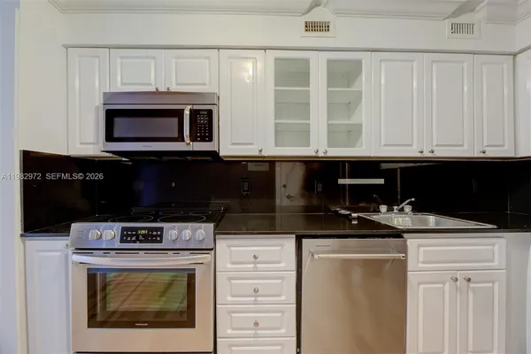 a kitchen with stainless steel appliances granite countertop a stove and a microwave