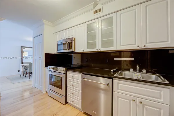 a kitchen with stainless steel appliances granite countertop a stove a microwave and a sink