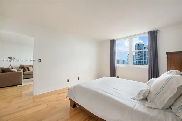 a bedroom with a large bed and wooden floor