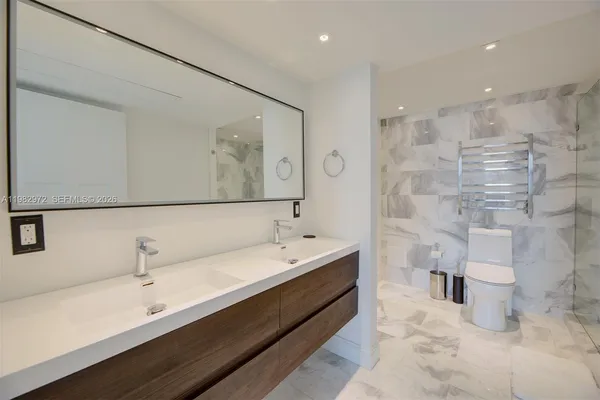 a spacious bathroom with a double vanity sink toilet and a mirror