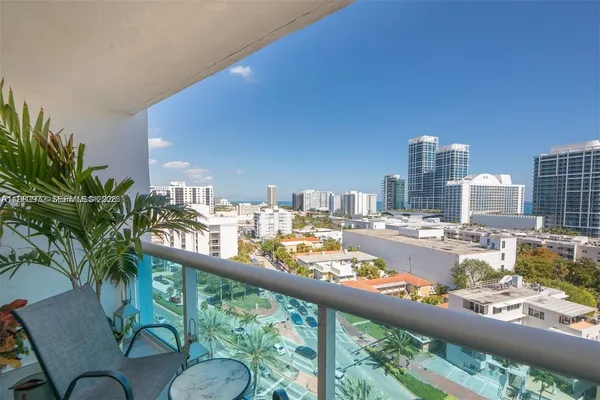 a view of a balcony with dining table and chairs