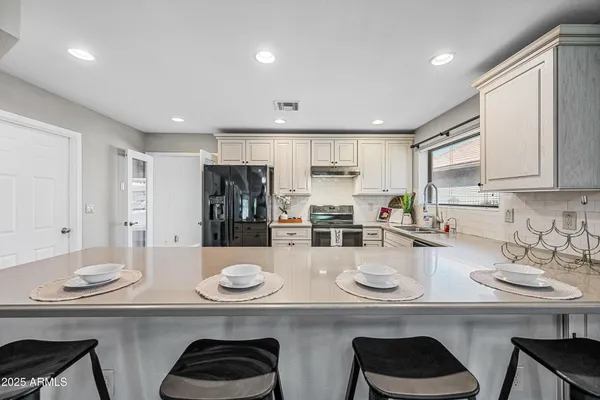 a kitchen with a sink stove cabinets and refrigerator