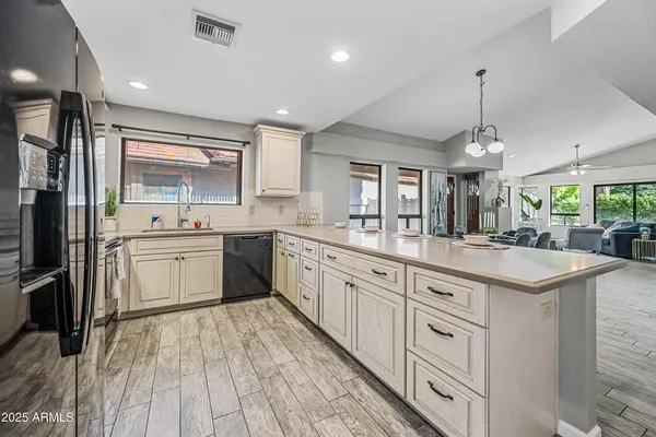 a kitchen with stainless steel appliances granite countertop a sink a stove and cabinets