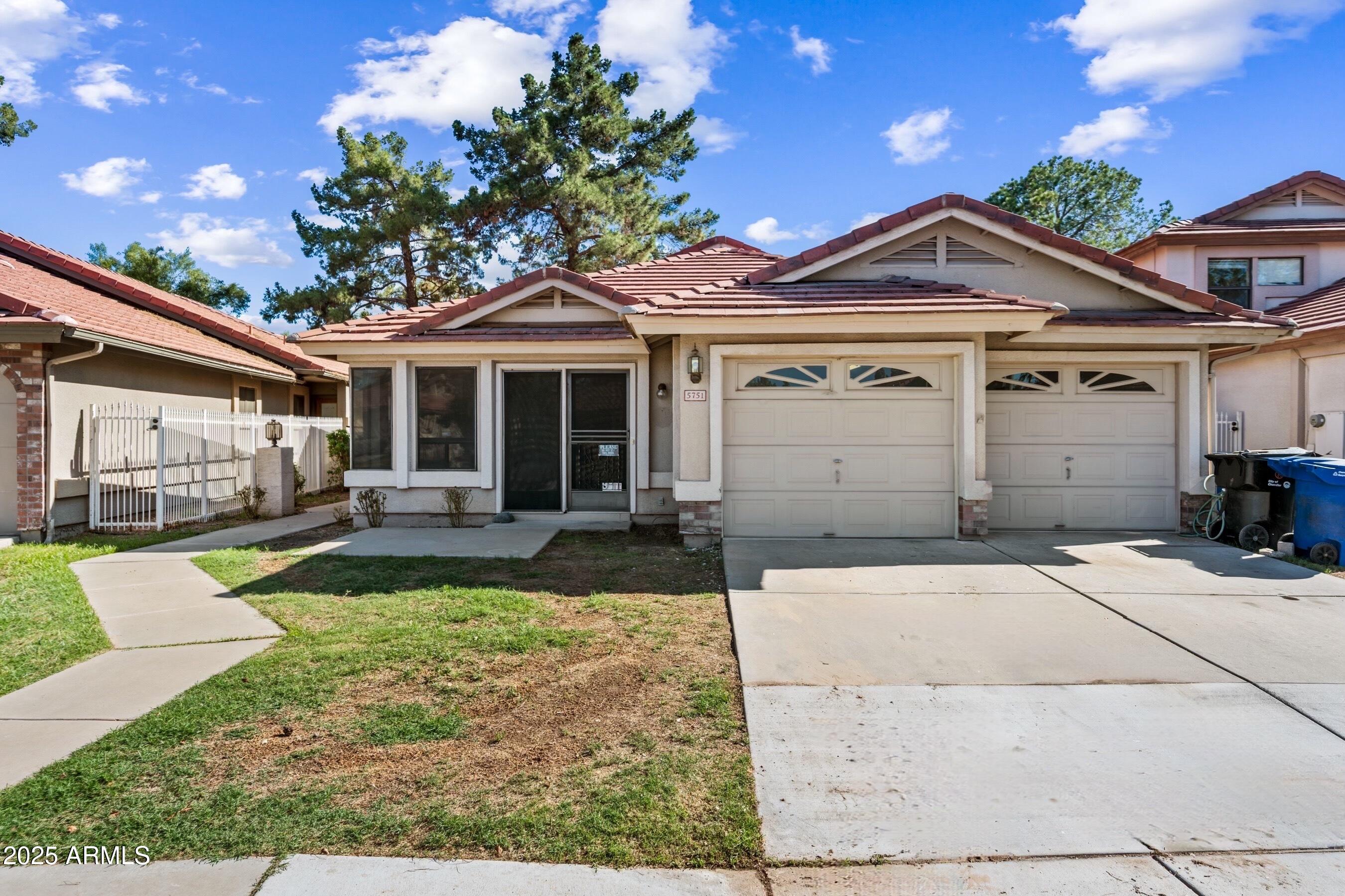 5751 West Del Rio Street Chandler, AZ 85226 - Photo 2 of 44 a view of a white house with a large tree and a yard