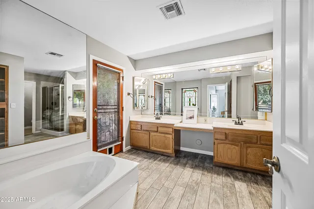 a spacious bathroom with a double vanity sink and a mirror