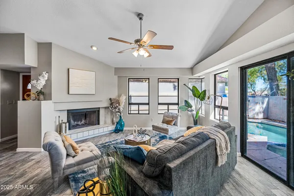 a living room with furniture a fireplace and a large window