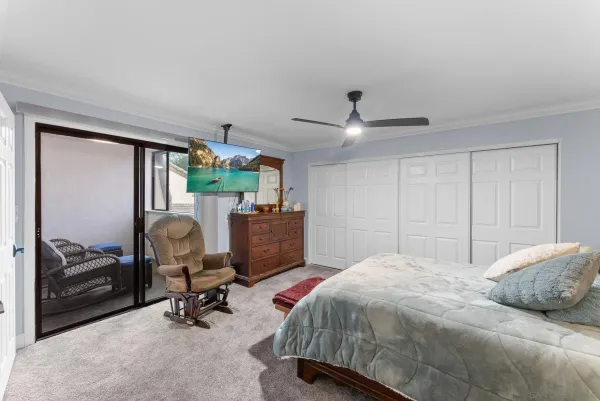 a bedroom with a bed gym equipment and a large window