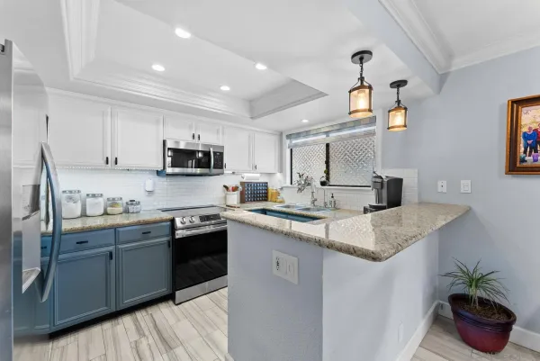 a kitchen with stainless steel appliances granite countertop a sink a stove and cabinets