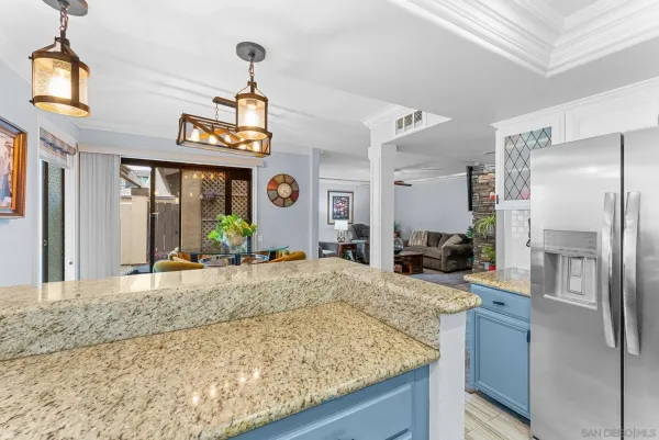a kitchen with stainless steel appliances granite countertop a sink a refrigerator and a granite counter top