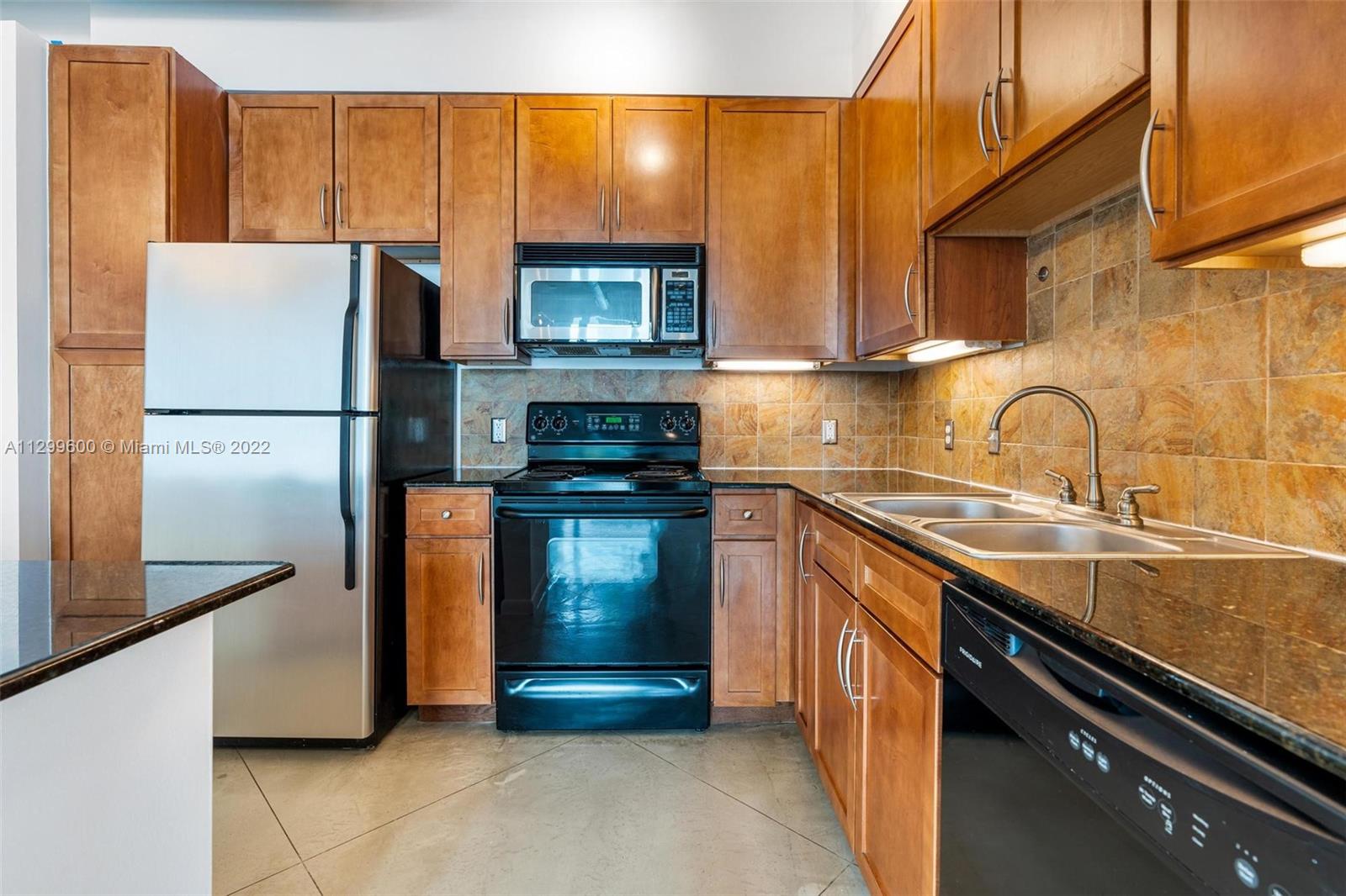 2001 Biscayne Boulevard, Unit 2308 Miami, FL 33137 - Photo 5 of 17 a kitchen with a refrigerator and a sink