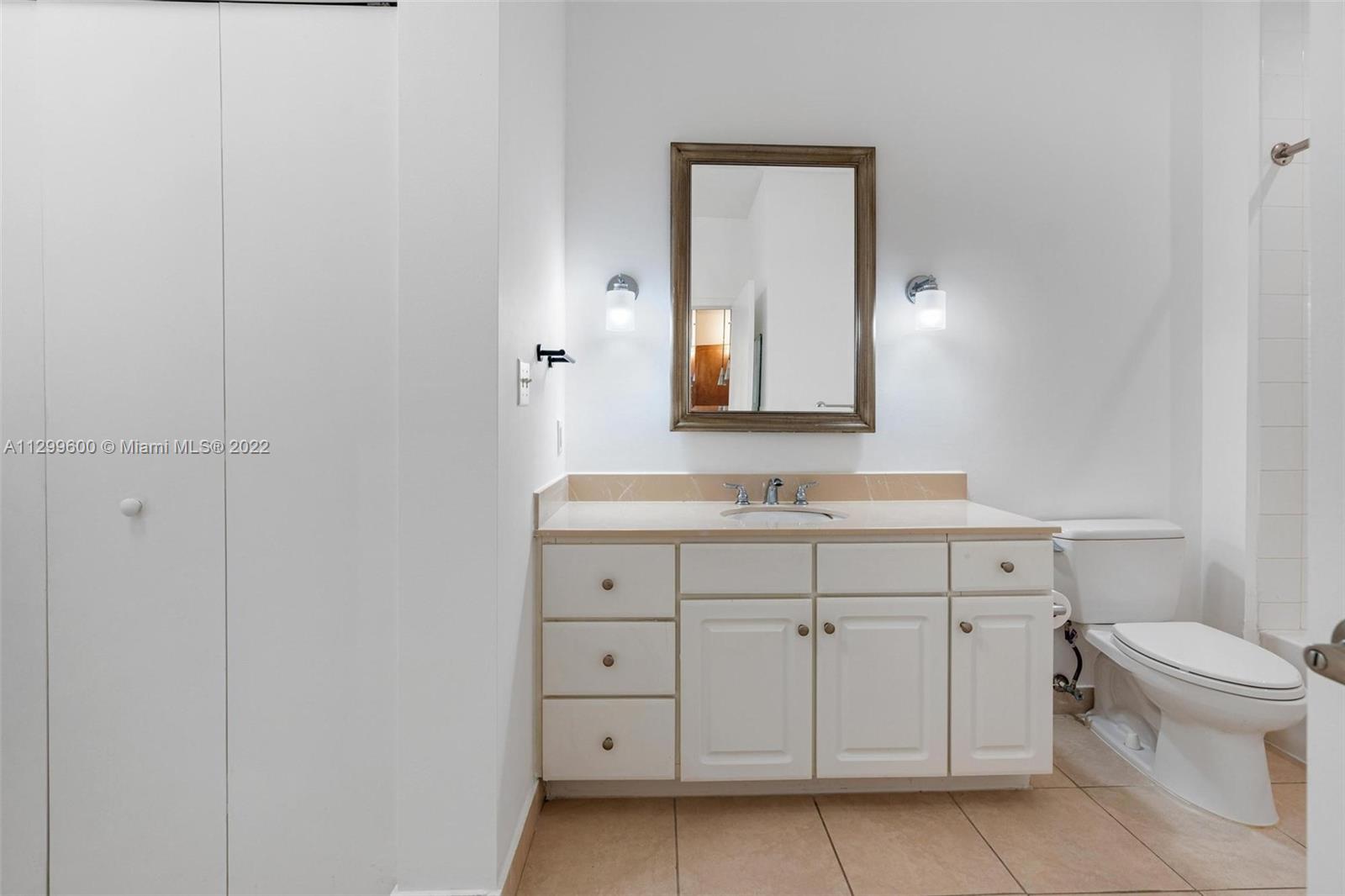 2001 Biscayne Boulevard, Unit 2308 Miami, FL 33137 - Photo 10 of 17 a bathroom with a sink a toilet and a mirror