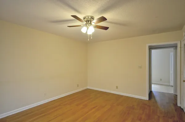 a view of an empty room with wooden floor