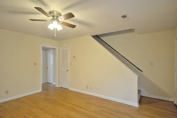 a view of an empty room with wooden floor