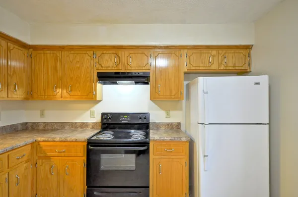 a kitchen with a refrigerator and a stove