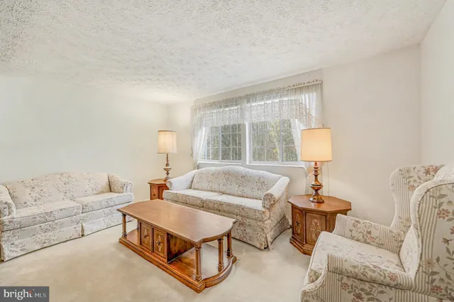 a living room with furniture a lamp and a table