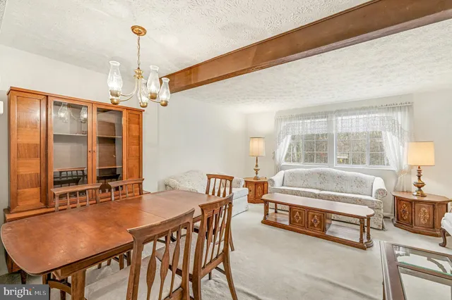 a spacious bedroom with a bed a table and a chandelier