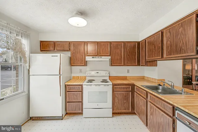 a kitchen with a white stove top oven and refrigerator