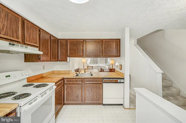 a kitchen with stainless steel appliances a stove a sink and a refrigerator
