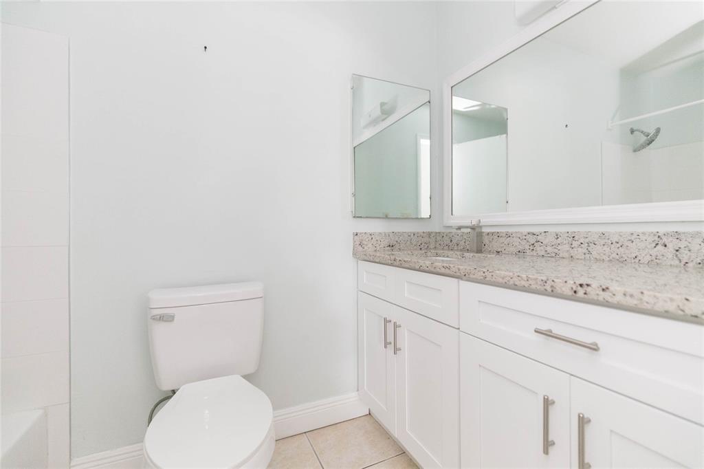 7531 Abonado Road, Unit 1 Tampa, FL 33615 - Photo 14 of 26 a bathroom with a granite countertop toilet and a sink