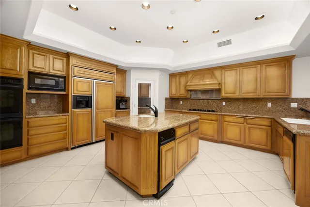 a kitchen with granite countertop a sink a stove and cabinets
