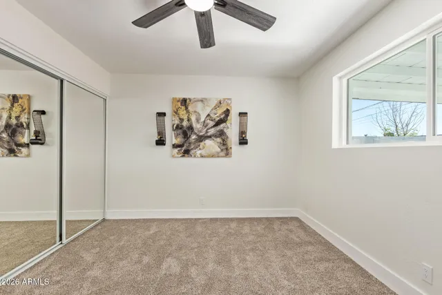 a view of empty room with wooden floor and ceiling fan