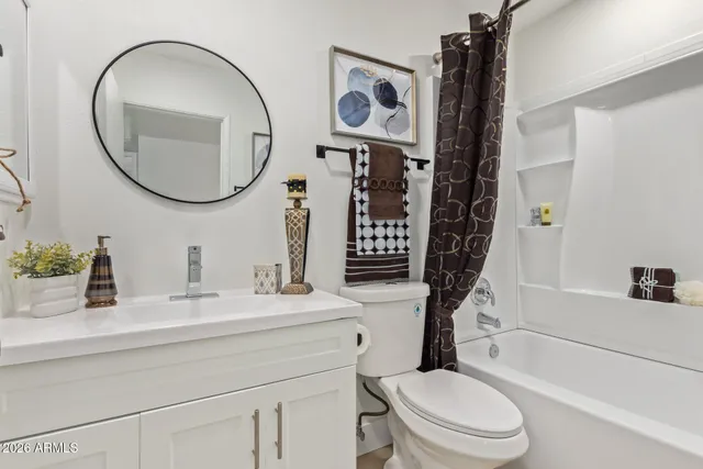 a bathroom with a toilet sink vanity tub and mirror
