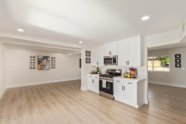 a kitchen with stainless steel appliances a stove top oven a sink a window and cabinets