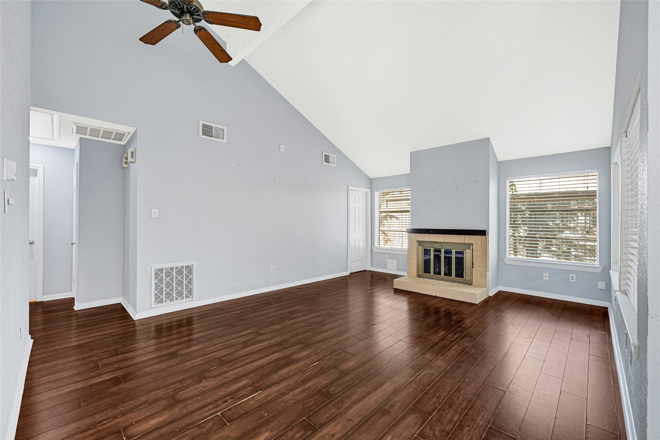 18562 Meadows Way Drive Houston, TX 77084 - Photo 9 of 11 an empty room with wooden floor fireplace and windows
