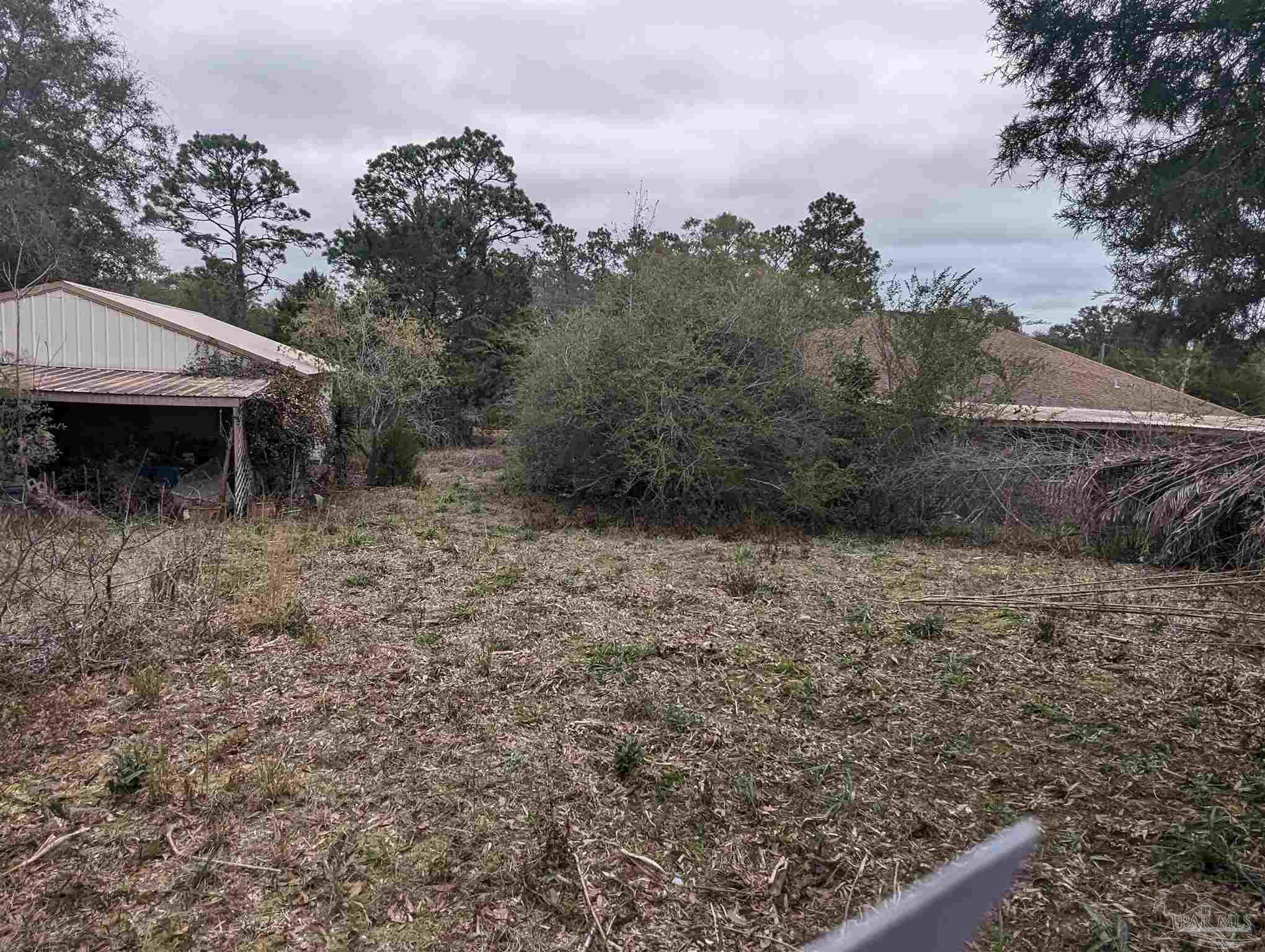 7759 Erudition Avenue Milton, FL 32583 - Photo 9 of 22 a view of a barn in the middle of a yard
