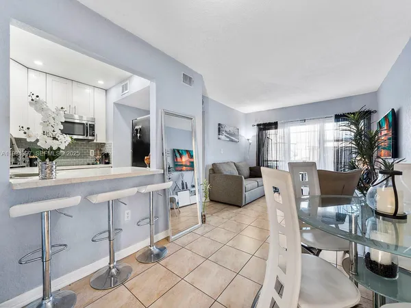 a living room with furniture a flat screen tv and a view of kitchen