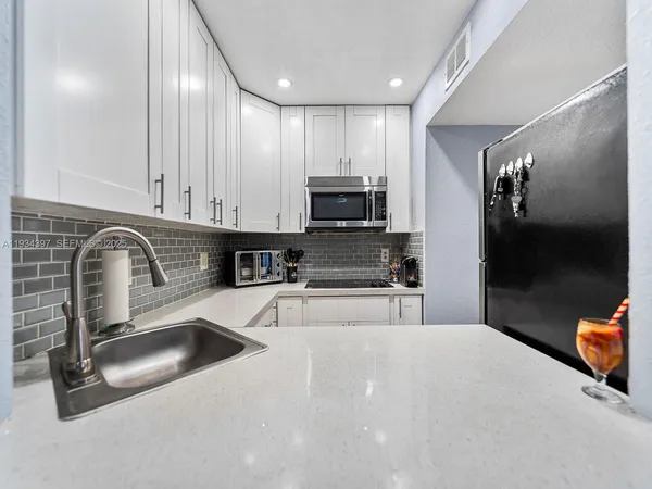 a kitchen with stainless steel appliances granite countertop a sink a stove and a refrigerator