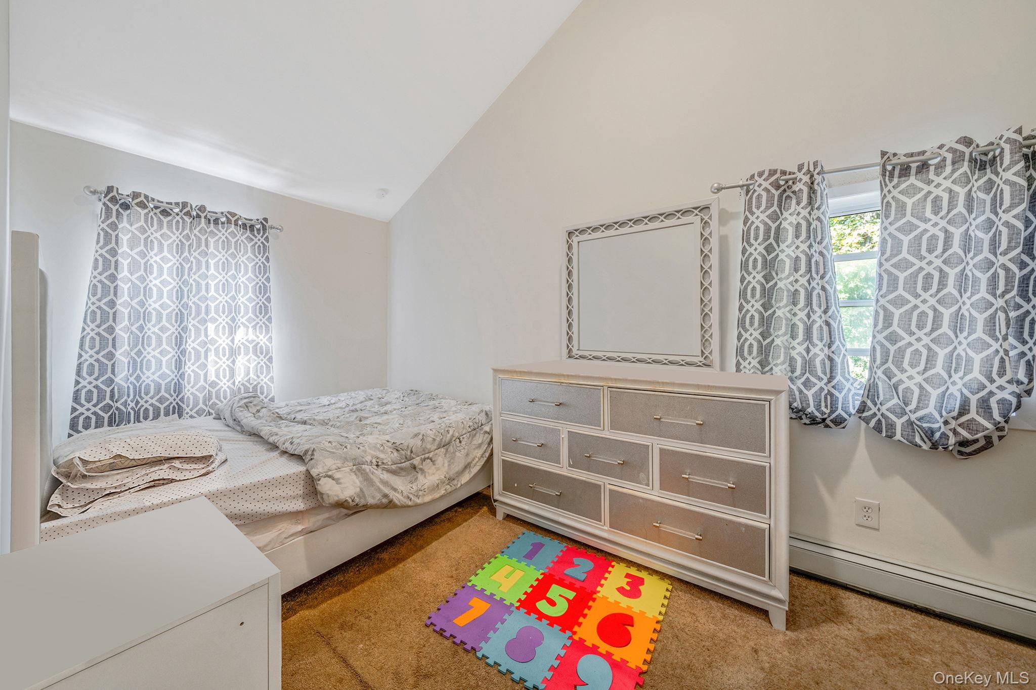 15 Sayville Road Mastic Beach, NY 11951 - Photo 11 of 25 a bedroom with a bed and a window