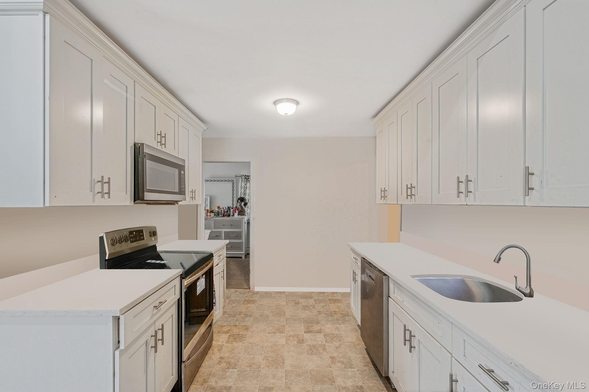 15 Sayville Road Mastic Beach, NY 11951 - Photo 9 of 25 a kitchen with stainless steel appliances granite countertop a sink stove and refrigerator