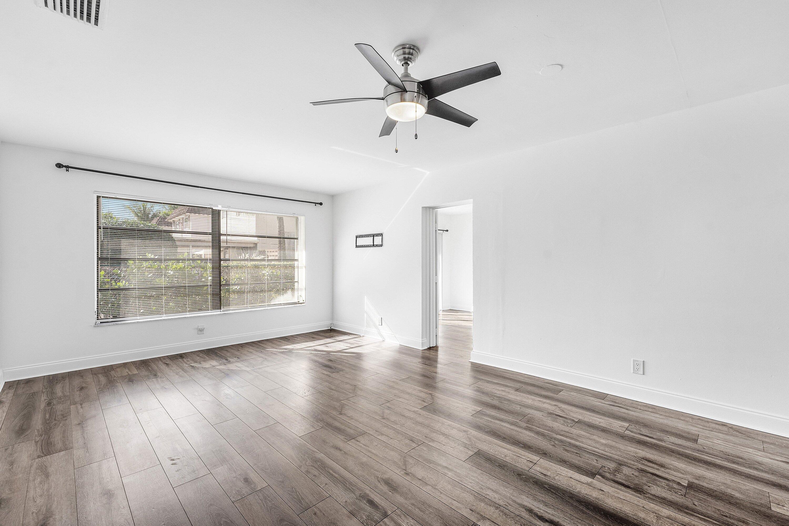 502 Northeast 48th Street Boca Raton, FL 33431 - Photo 16 of 30 an empty room with wooden floor fan and windows