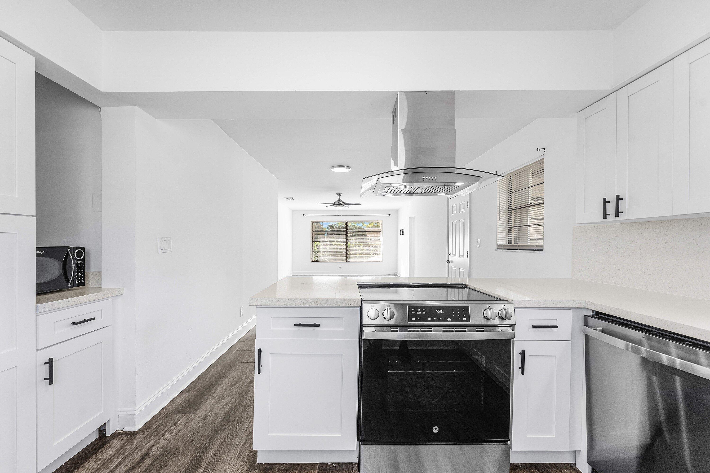 502 Northeast 48th Street Boca Raton, FL 33431 - Photo 10 of 30 a kitchen with cabinets stainless steel appliances and wooden floor