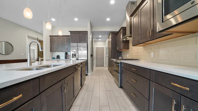 a large kitchen with stainless steel appliances kitchen island granite countertop a sink and cabinets