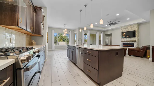 a kitchen with stainless steel appliances granite countertop a stove a sink dishwasher and a refrigerator