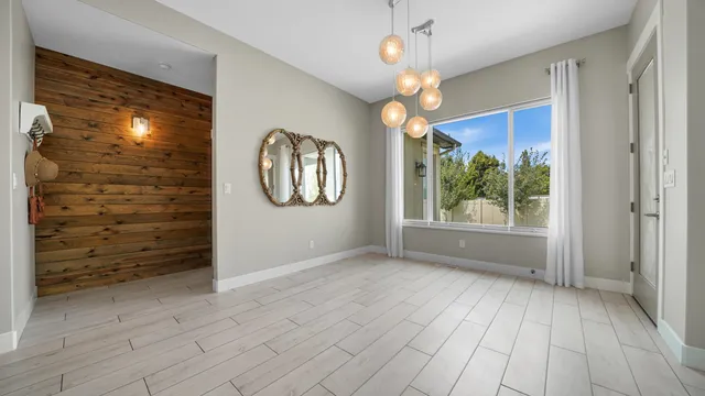 an empty room with wooden floor mirror and windows