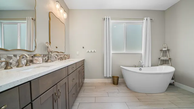 a bathroom with a double vanity sink mirror and bathtub