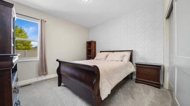 a bed sitting in a bedroom next to a window