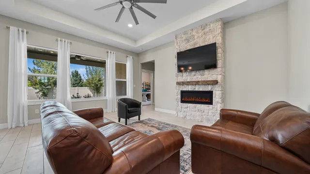 a living room with furniture a flat screen tv and a fireplace